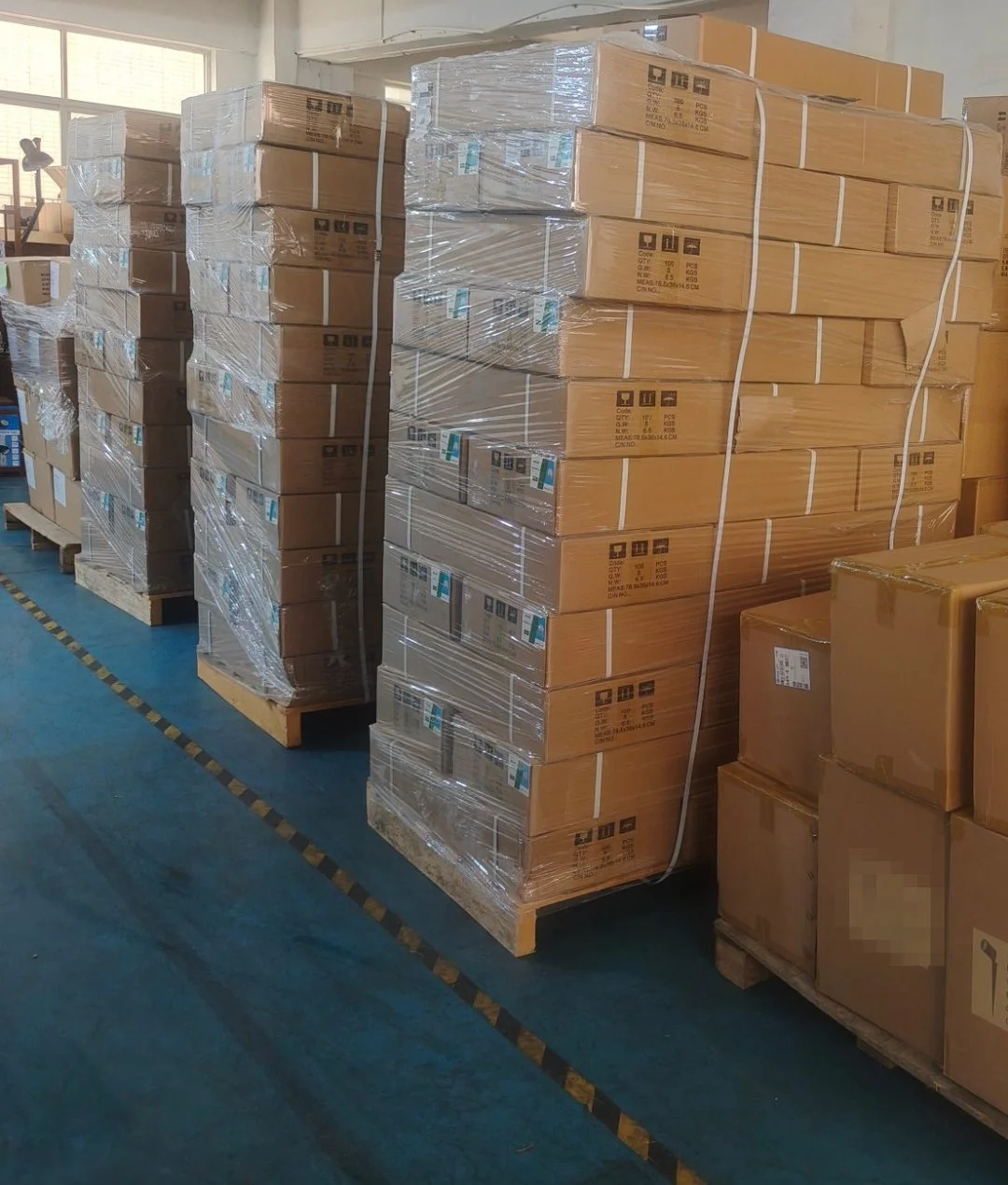 Stretch-wrapped and strapped pallets of LED lighting cartons in the warehouse