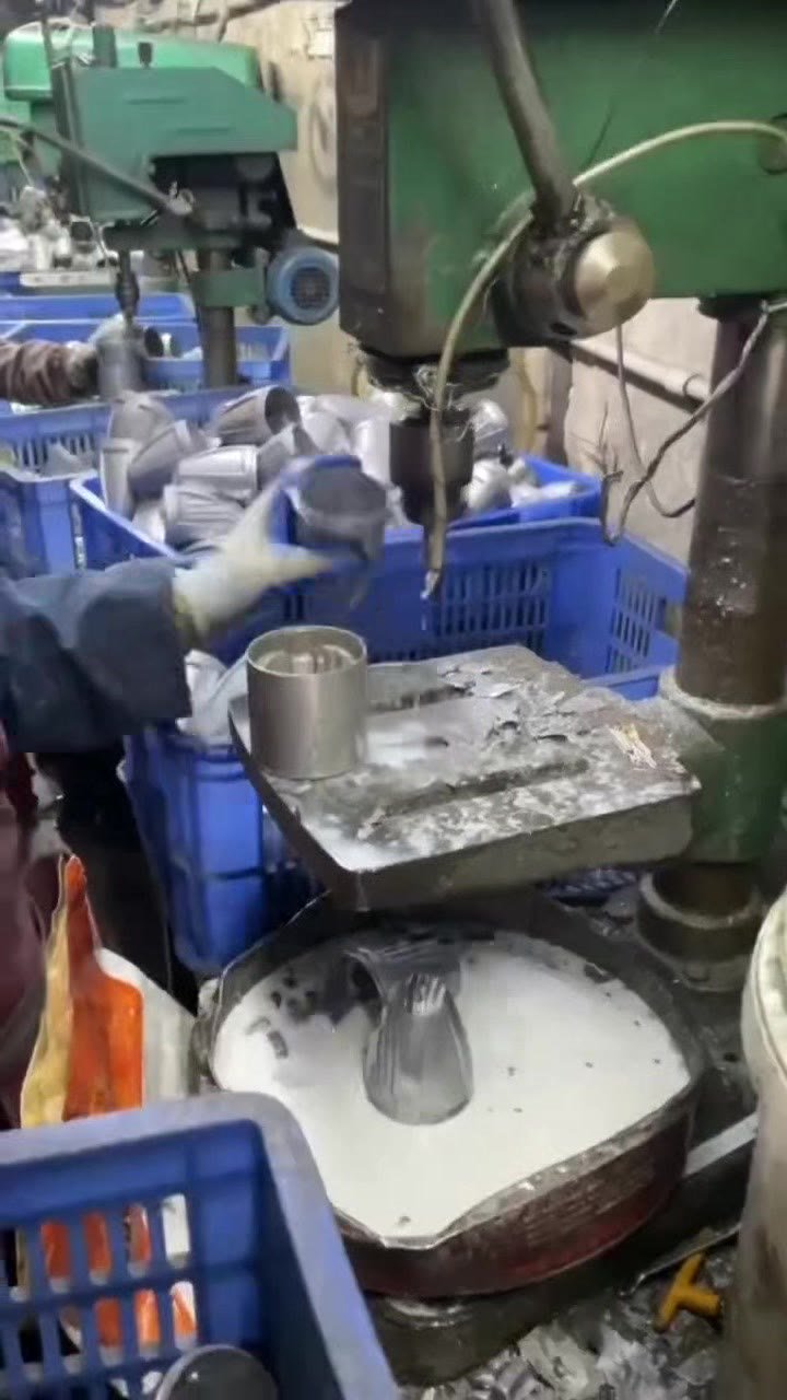 Worker processing metal LED lighting housings in the production workshop